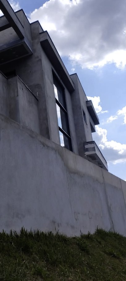 Obra externa em andamento, com muro de concreto